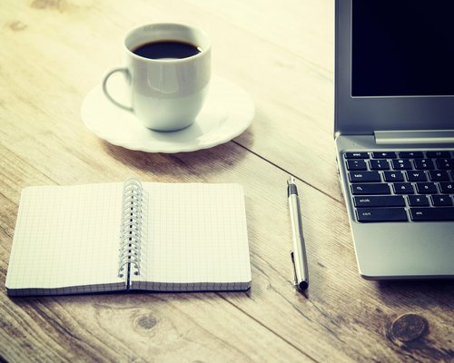laptop on a wooden desk with external keyboard